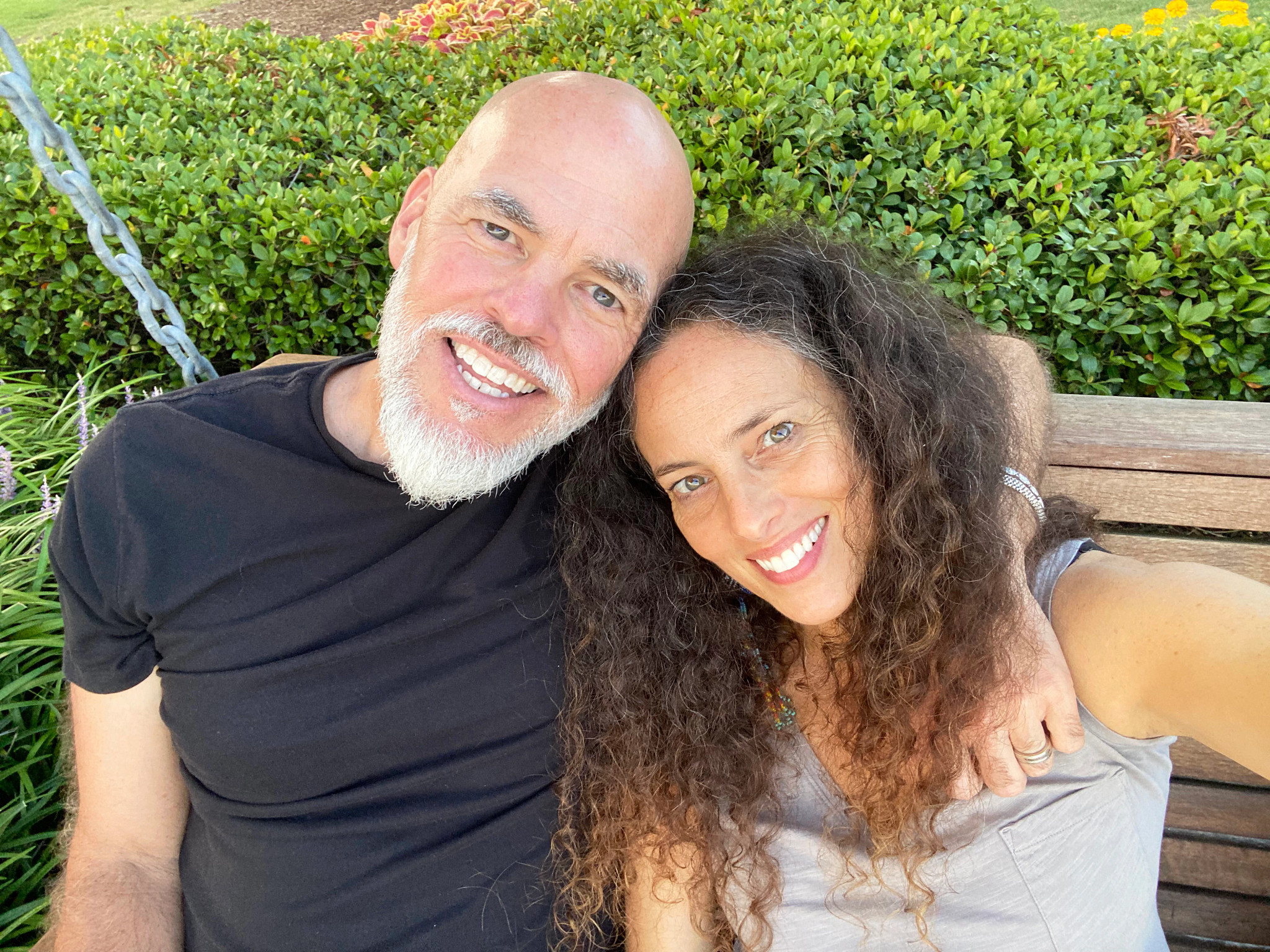 a photo shows author Matthew Quick and his wife Alicia sitting together on a porch swing, smiling