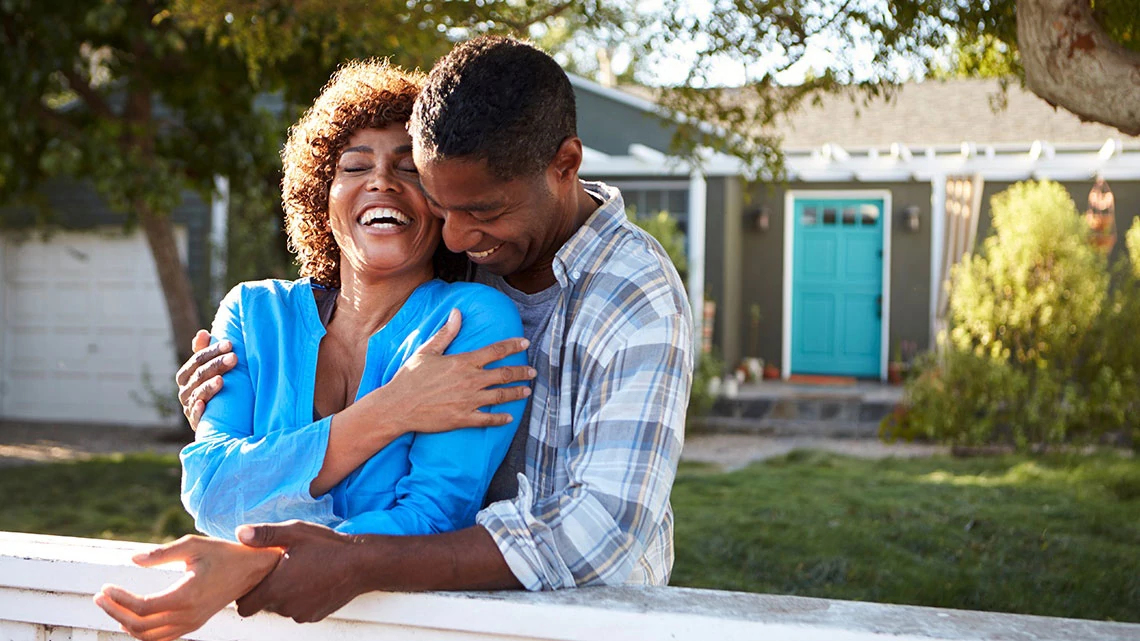 Laughing couple embracing outside