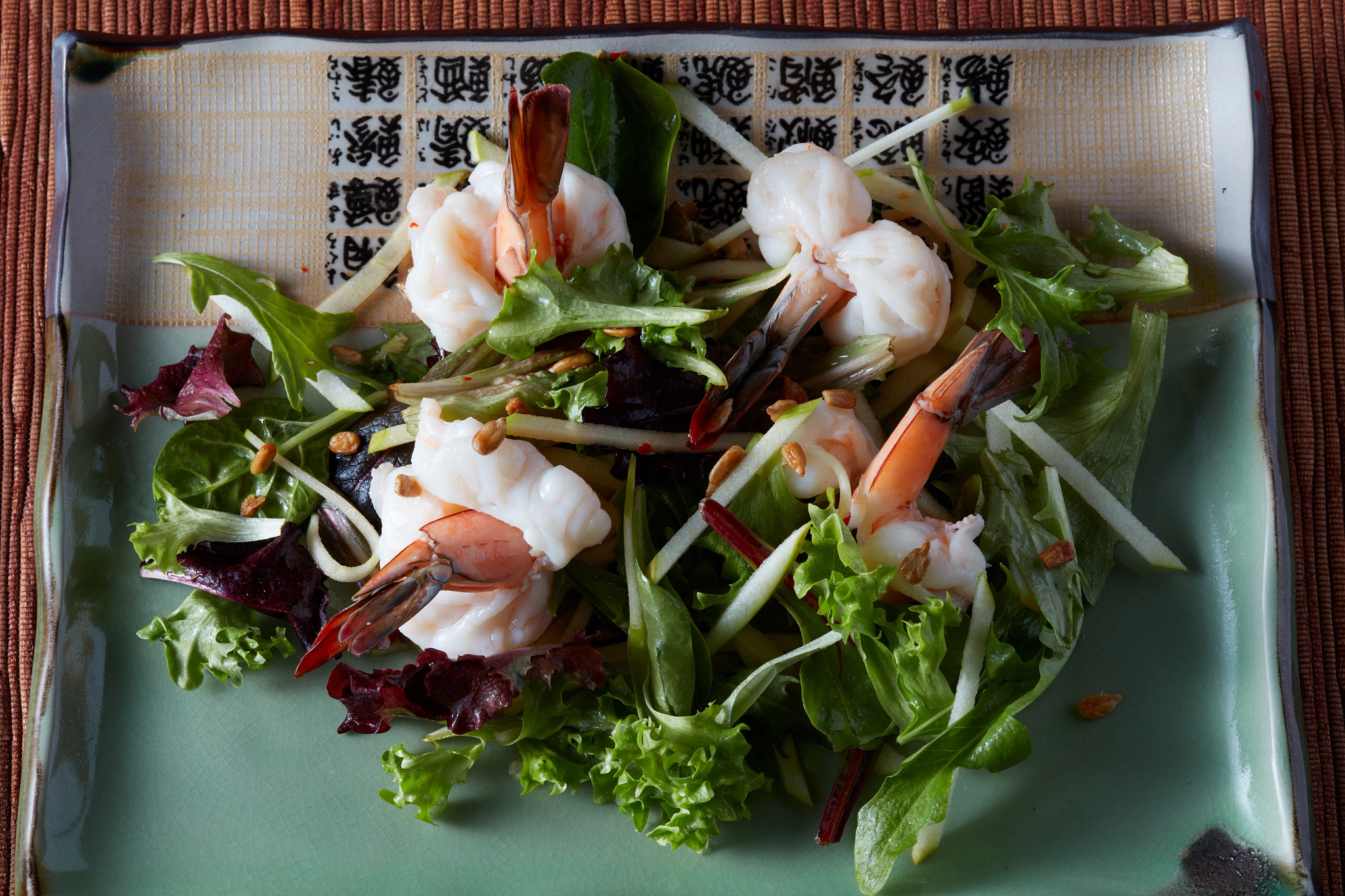A close-up view of a crisp apple and shrimp salad on a plate
