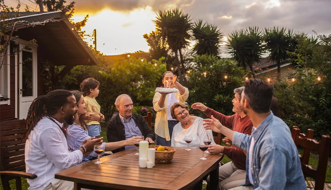 Group of friends enjoying wine together at a birthday party on outdoor patio