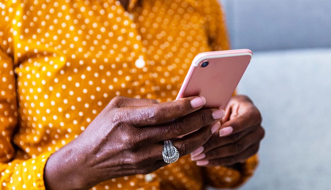 AARP works with google on designing devices that meet the needs of older adults A woman's hands holding a smartphone