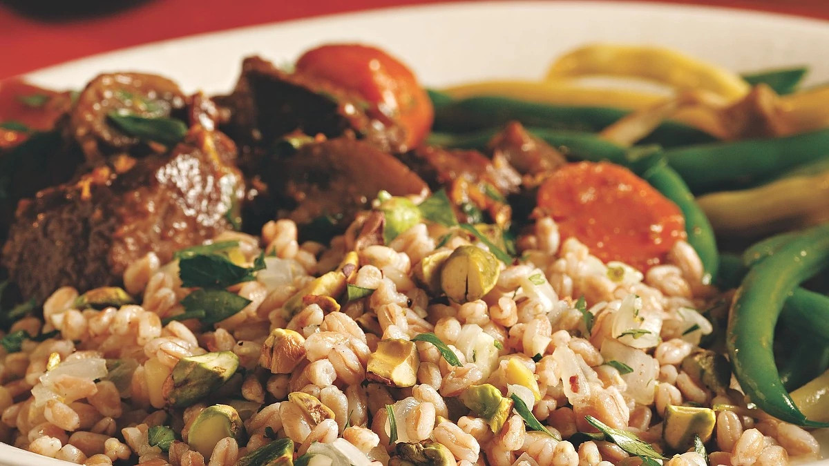 A close-up view of farro with pistachios and herbs