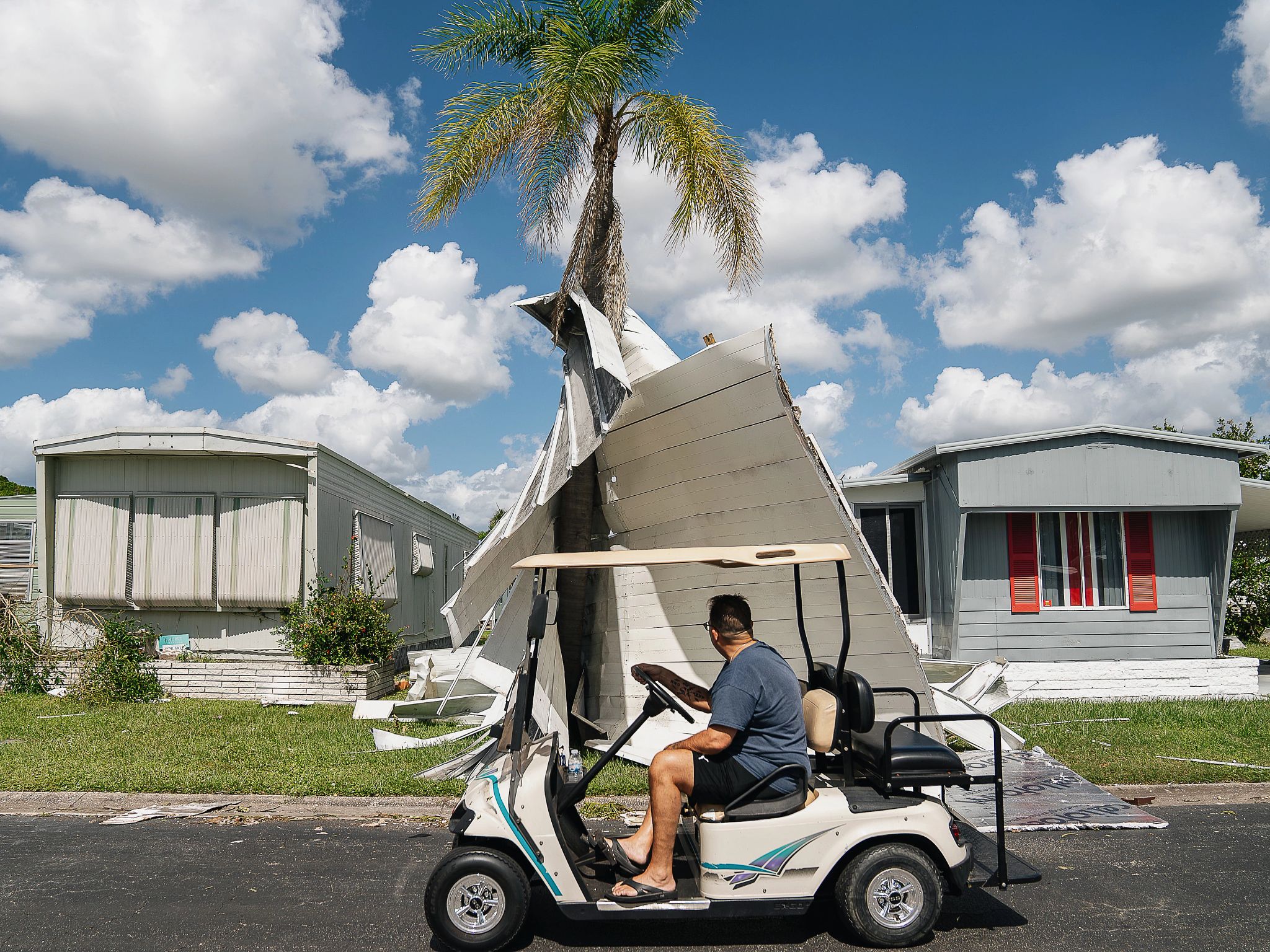 Best AARP Photos of 2024 a person on a golf cart looking at a destroyed home