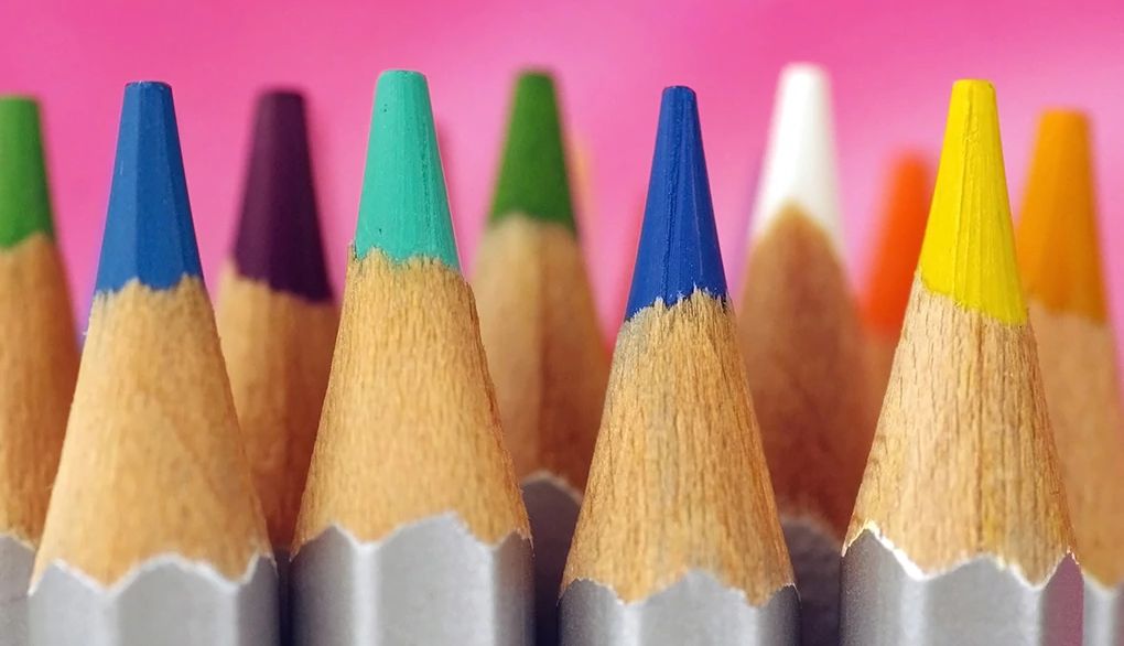Coloring can be a fun way to relieve stress Multi-colored pencil points on vibrant background