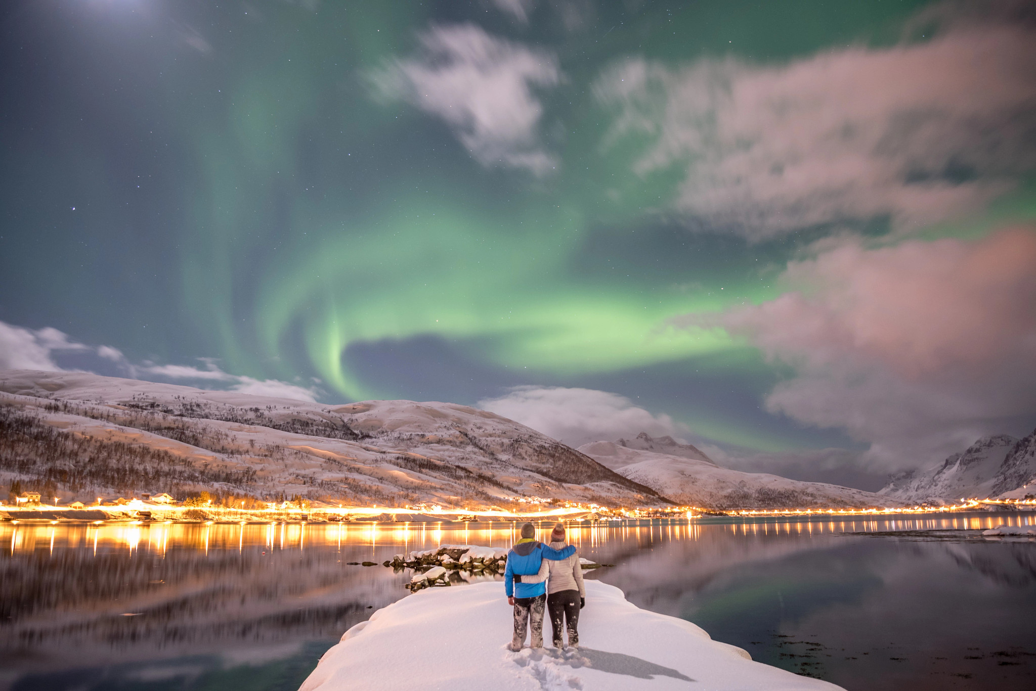 Couple looking at aurora borealis in Tromso, Norway