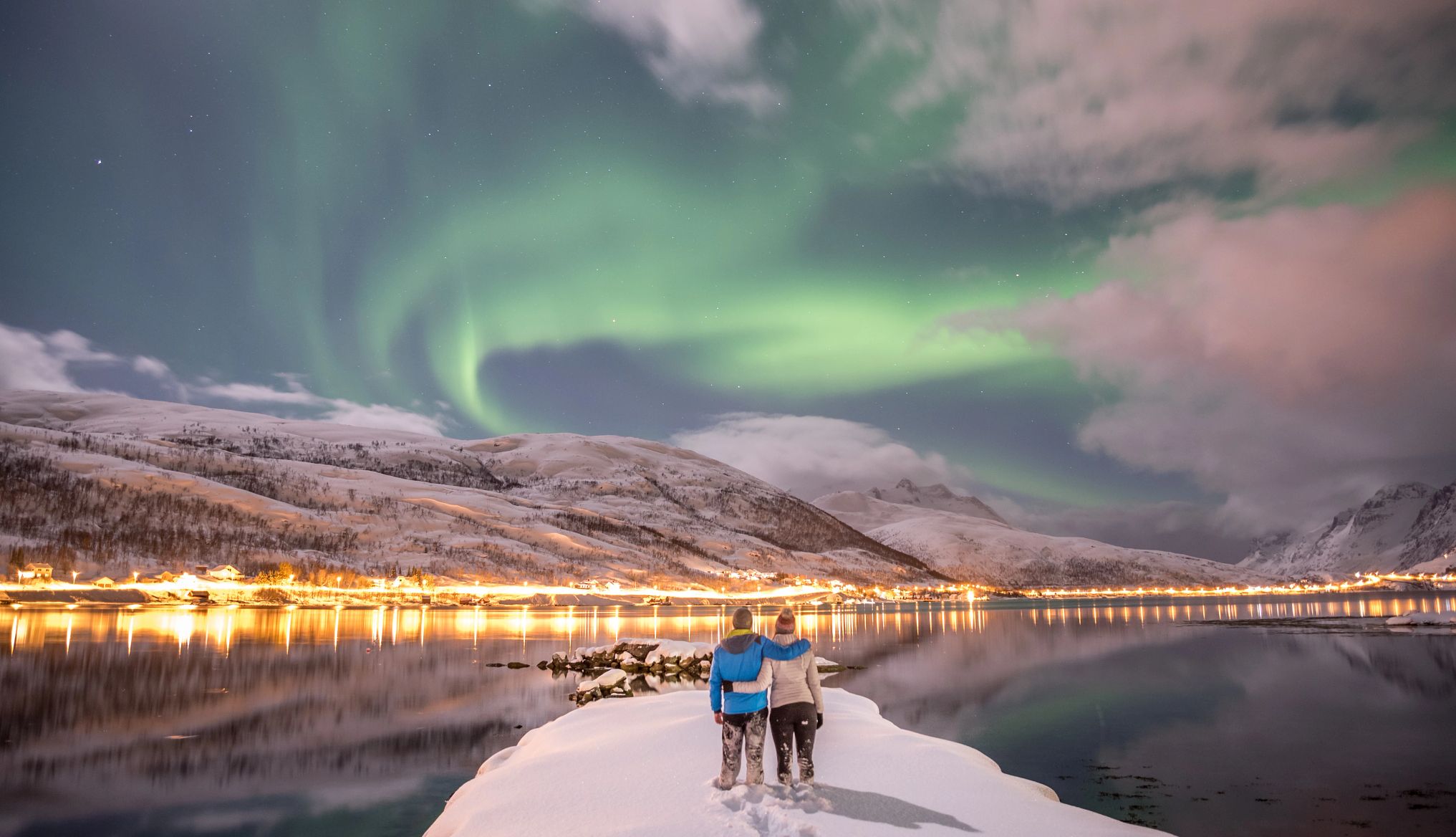 The Northern Lights are visible from Norway Couple looking at aurora borealis in Tromso, Norway
