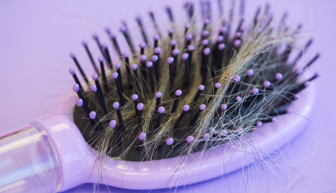purple hairbrush with hair 