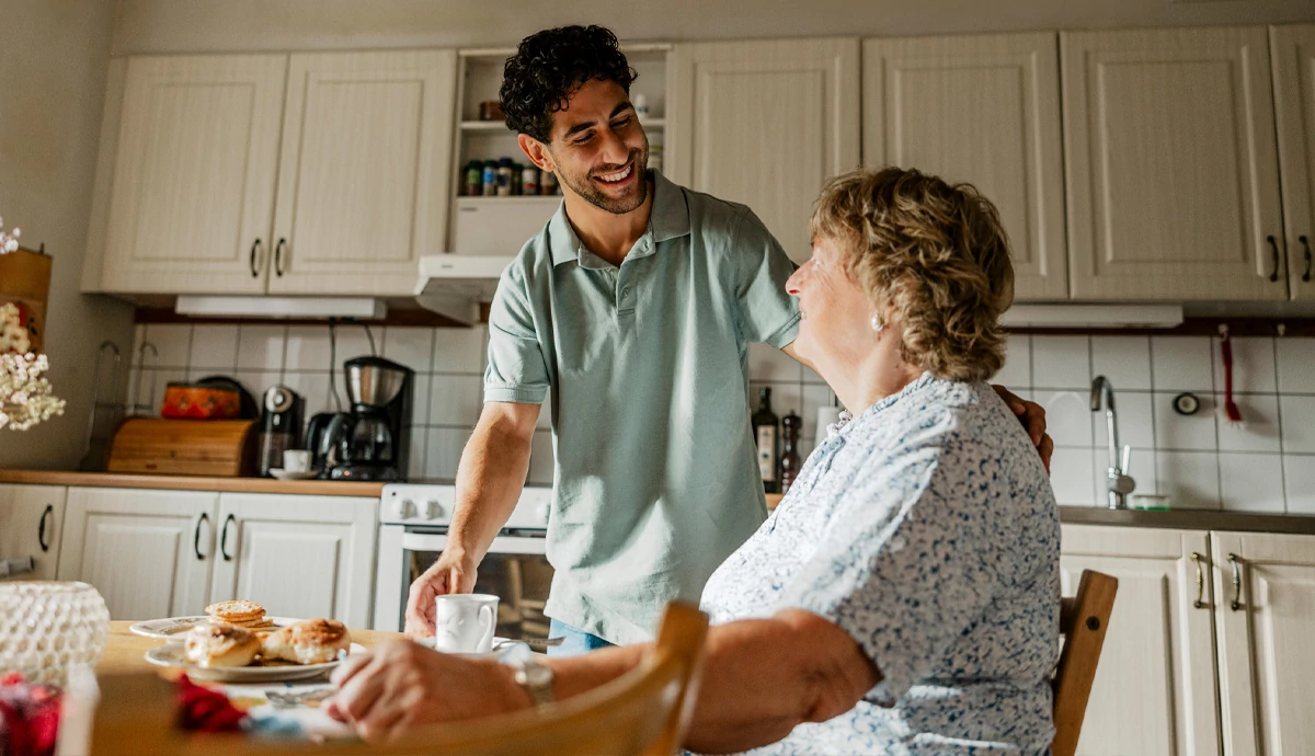 Woman and son in a kitchen smiling and laughing.