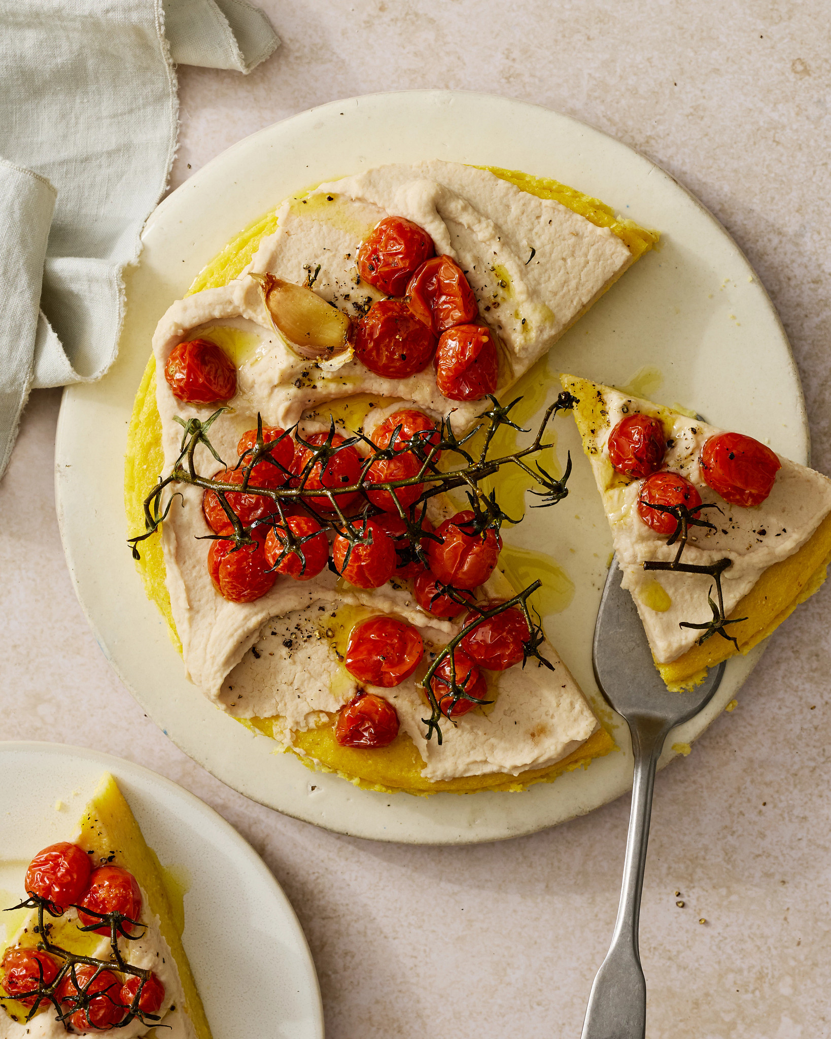 Vegan Polenta Tart With White Bean Spread and Oven-Roasted Tomatoes is shown in a photo