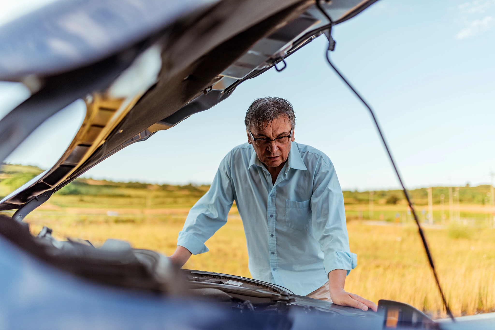 stressed man having trouble with his broken car