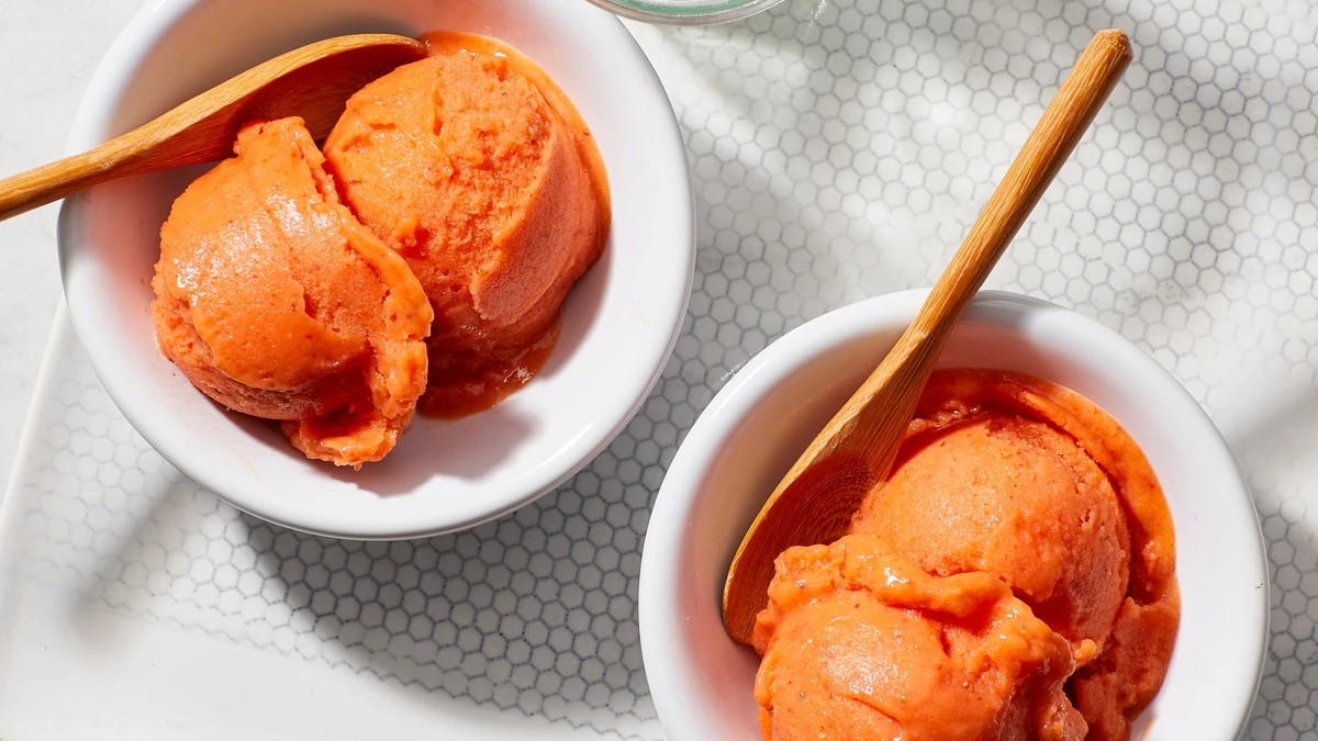 A close-up view of strawberry-mango nice cream in bowls with spoons