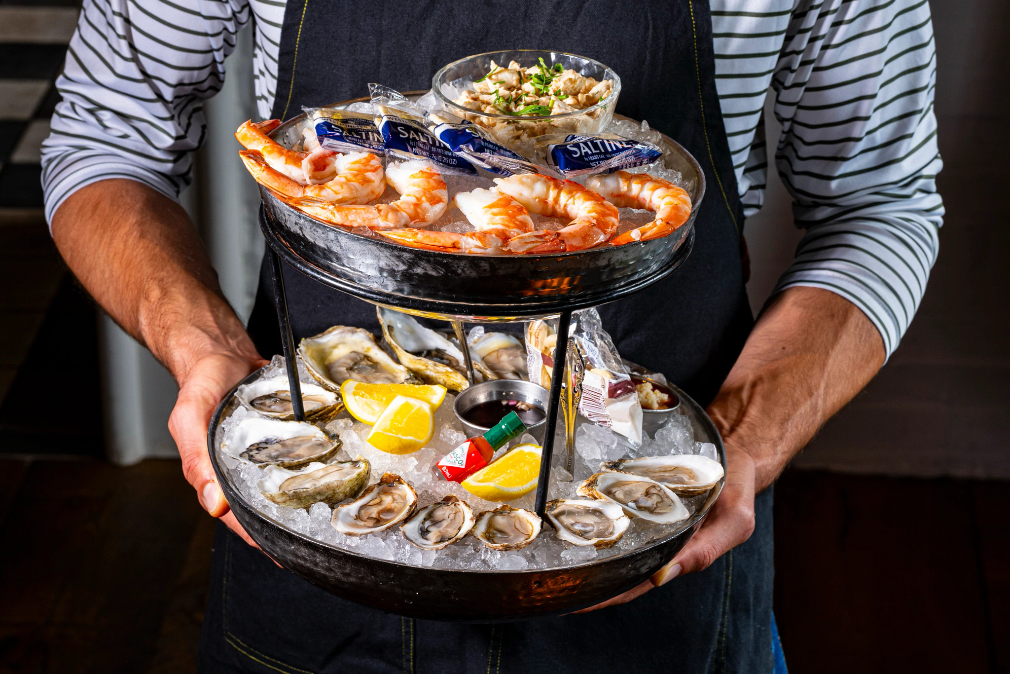 A server shows off the Mermaid Seafood Tower at Cordelia Fishbar in Washington, D.C.