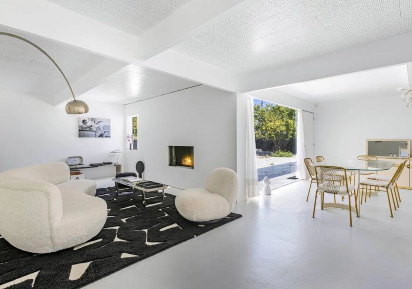 Steve McQueen home a living room with a fireplace and white and black decor