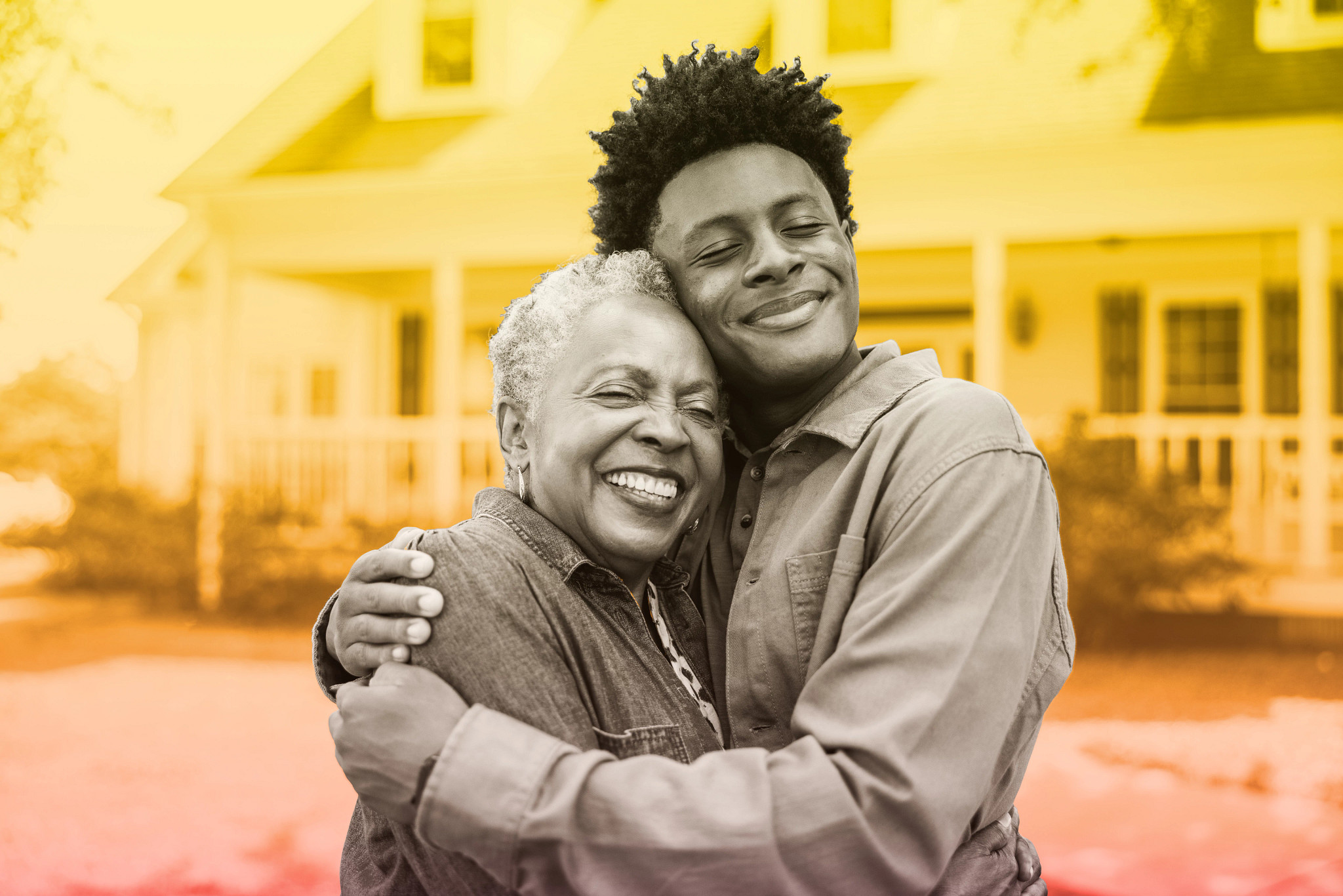 Portrait of senior woman and grandson in front of rural farm home