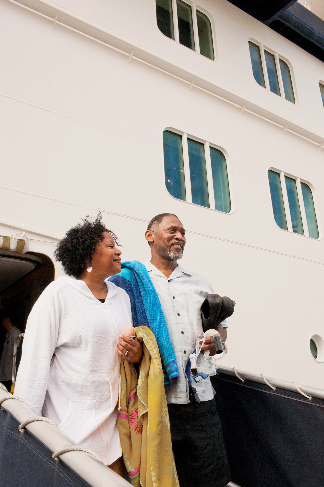 a couple leaving cruise ship with towels and snorkeling gear