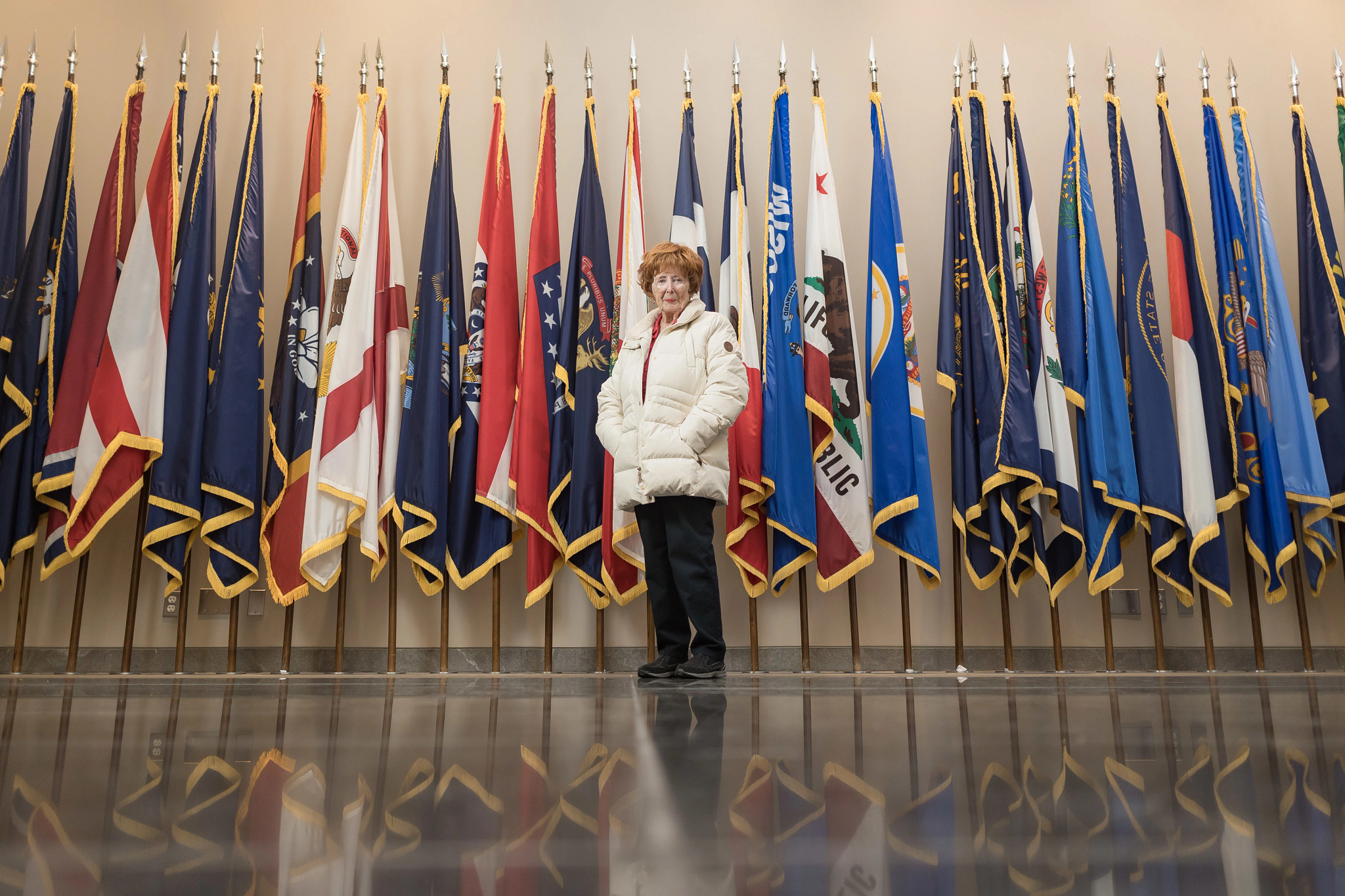 vicky herrell standing in front of a display with many flags