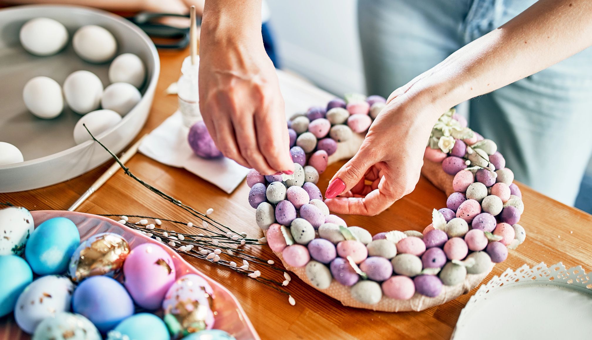 a woman putting together an Easter wreath