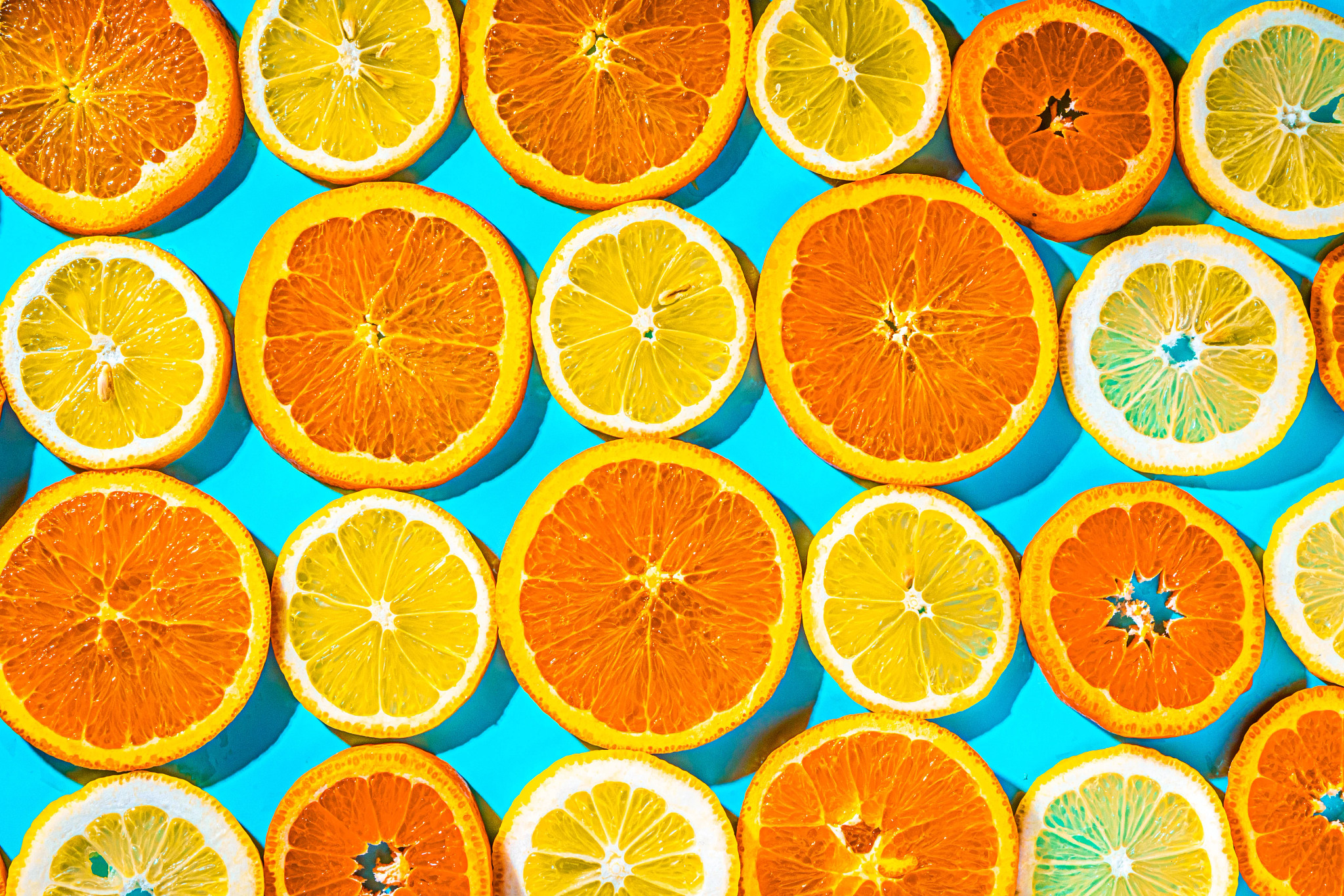 naranjas y limones en rodajas sobre fondo azul