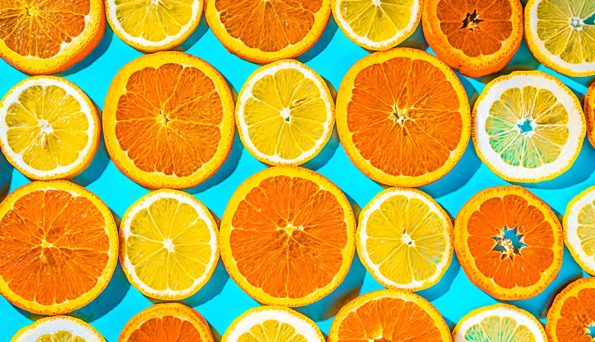 naranjas y limones en rodajas sobre fondo azul