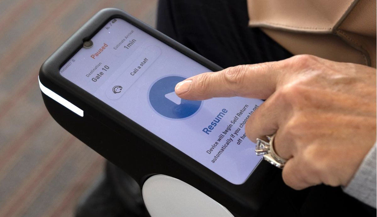 discover how a robotic wheelchair works woman using a touchscreen to program a robotic wheelchair