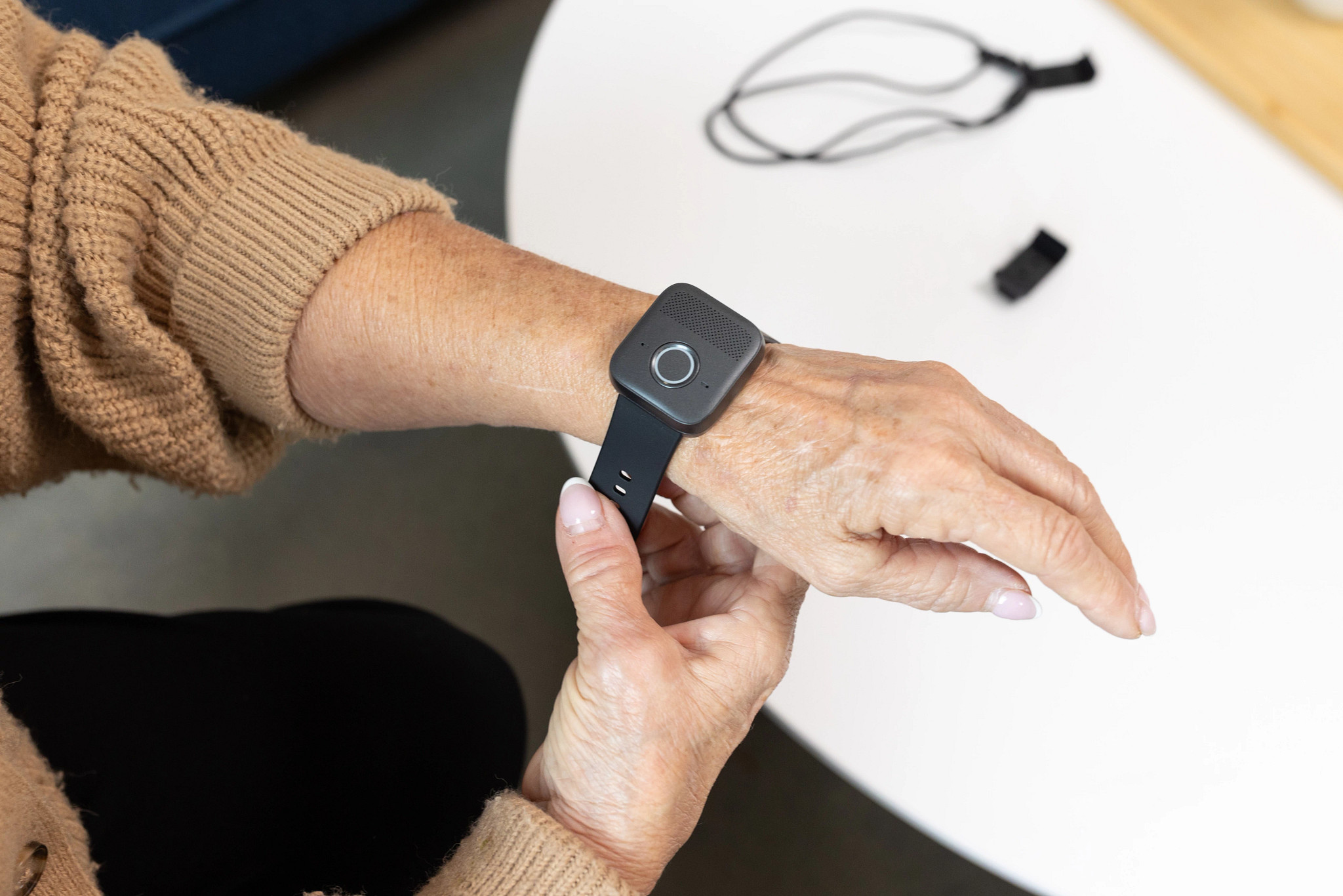  A woman putting the Bay Alarm Medical SOS Micro medical alert device on her wrist.