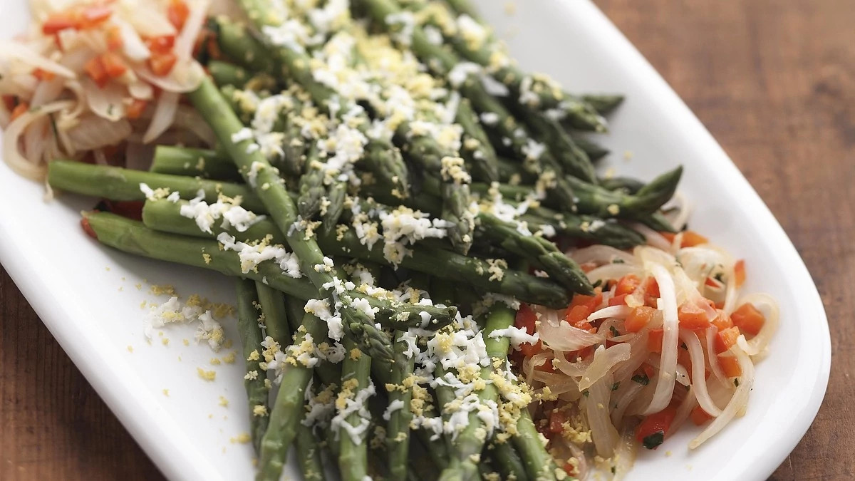 A close-up view of asparagus with red peppers on a plate