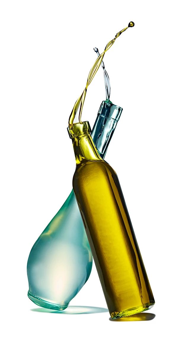 Bottle with coconut oil crossing with bottle of olive oil