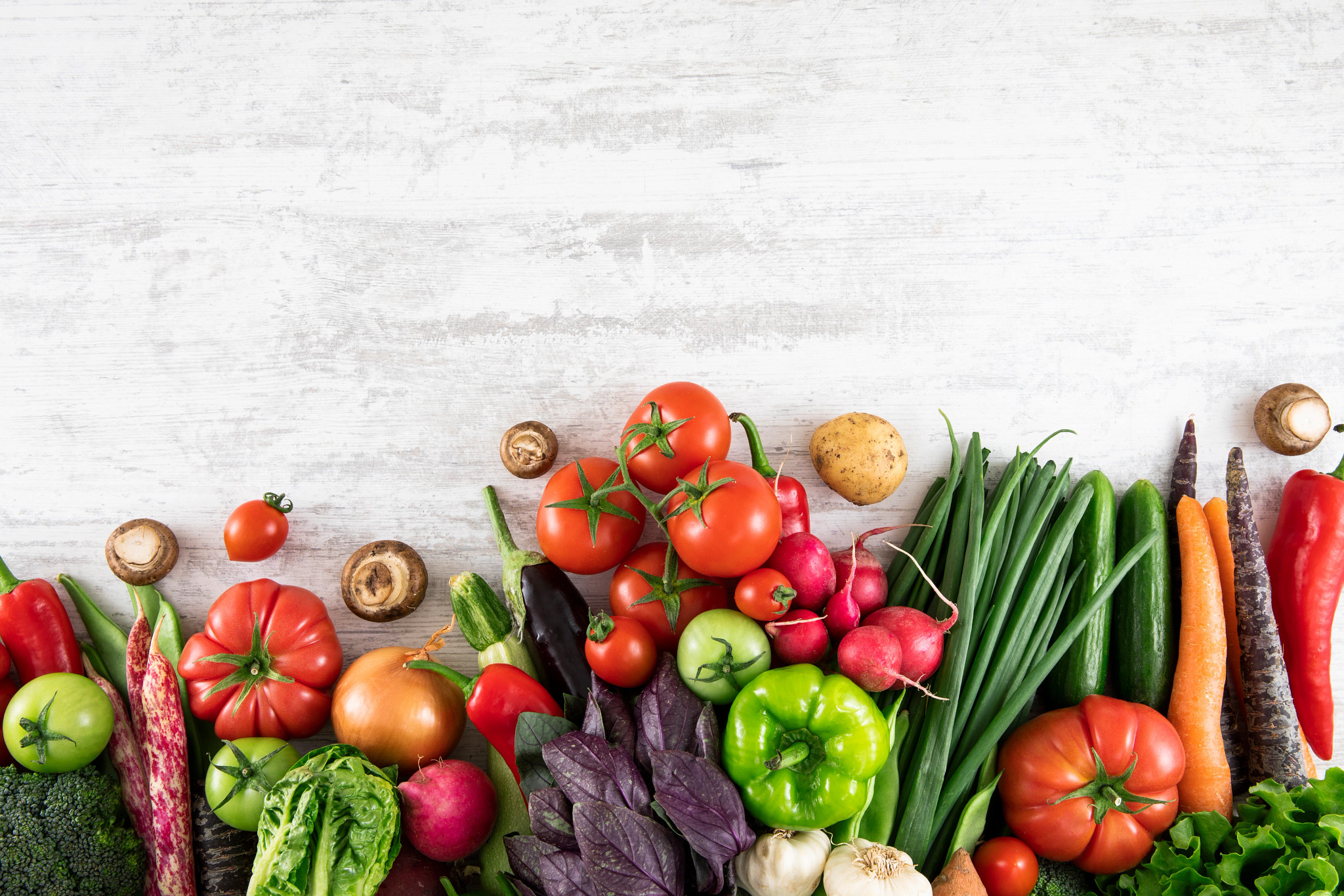 Fresh and raw vegetables on white wooden table with copy space
