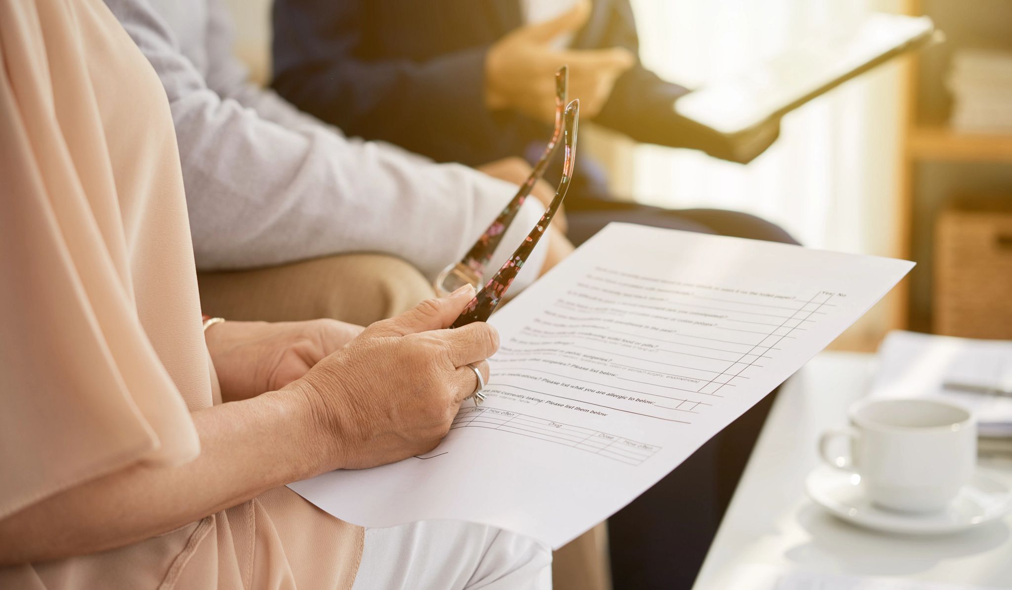 Close-up shot of senior husband and wife sitting at cozy office and studying life insurance policy, female agent assisting them Close-up shot of senior husband and wife sitting at cozy office and studying life insurance policy, female agent assisting them