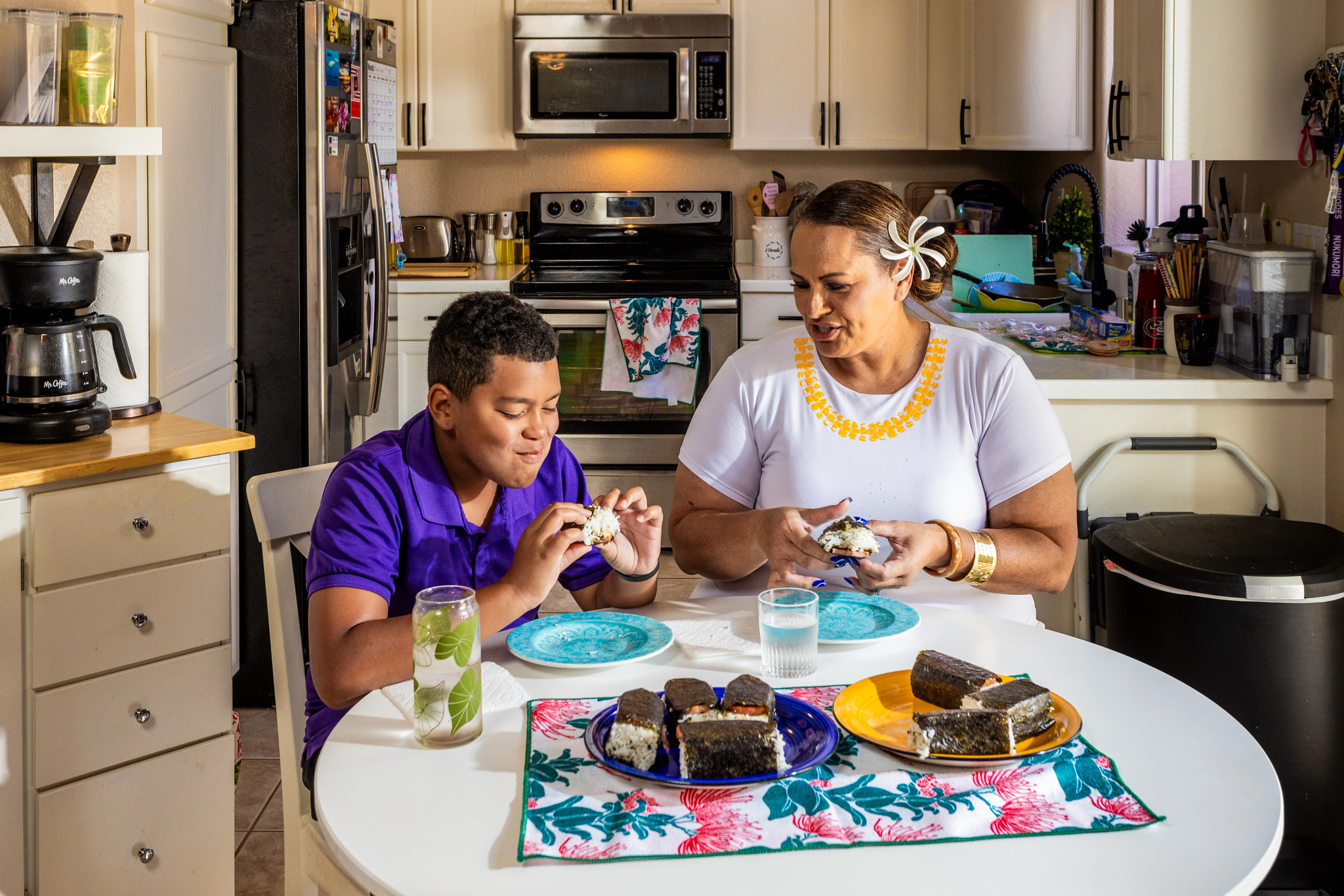 Doreen Hall Vann and son sitting at table in kitchen eating Spam Musubī