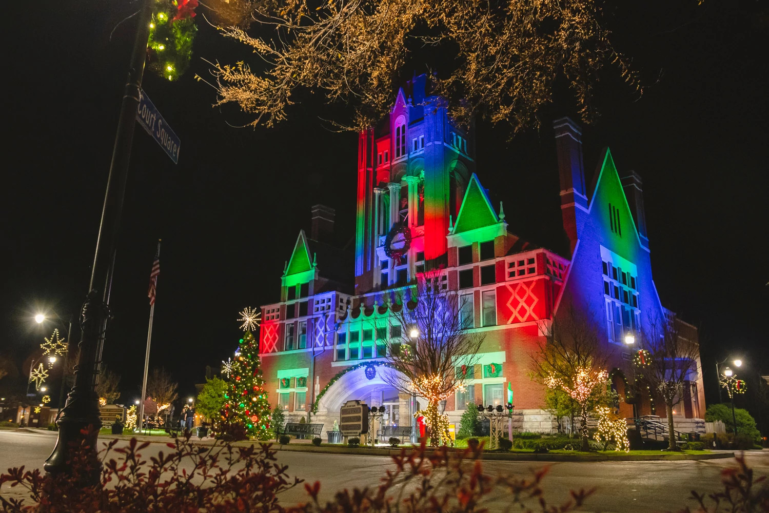 a historic courthouse lit up in festive colors