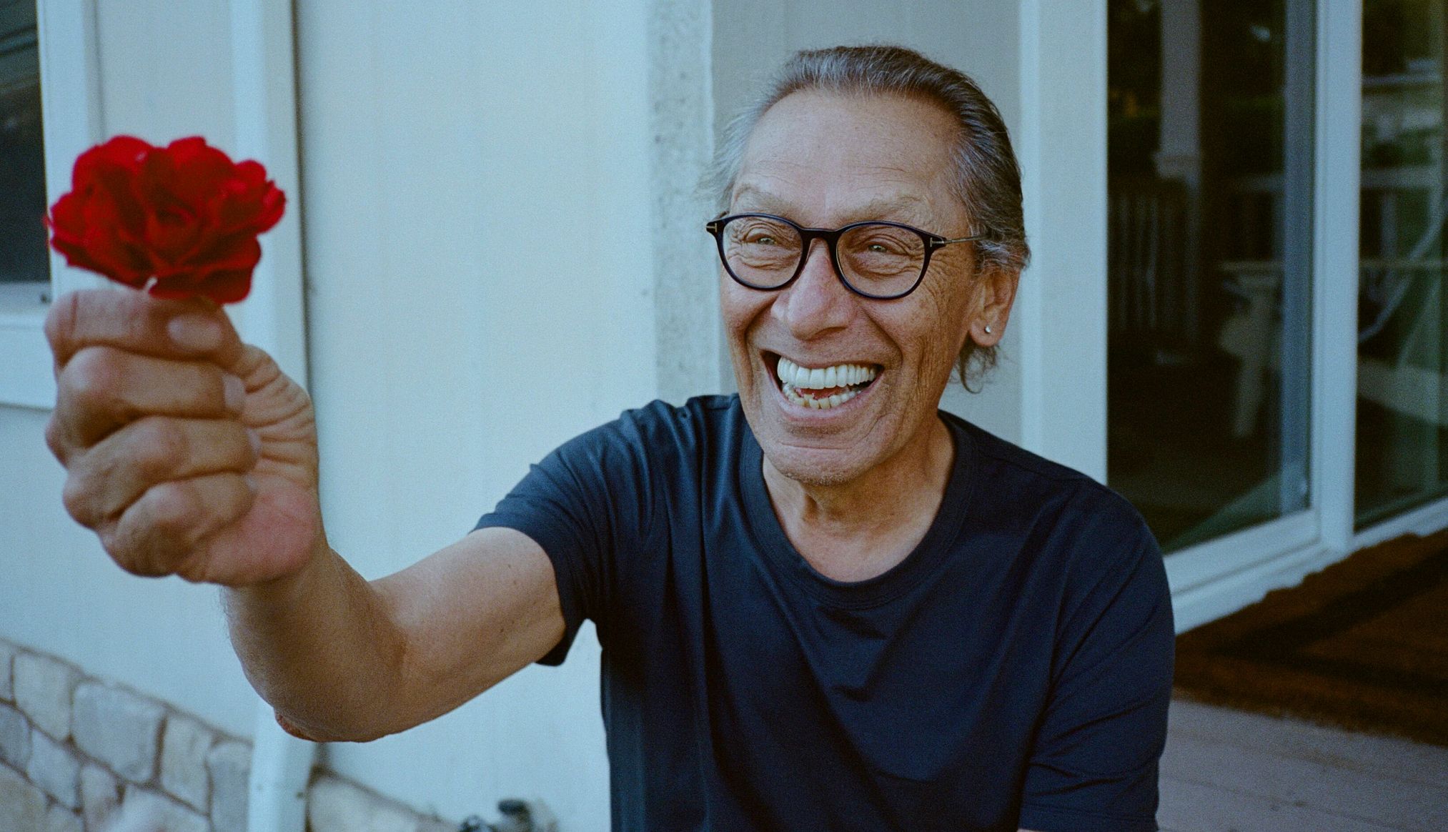 Alex Van Halen a smiling alex van halen holding a flower