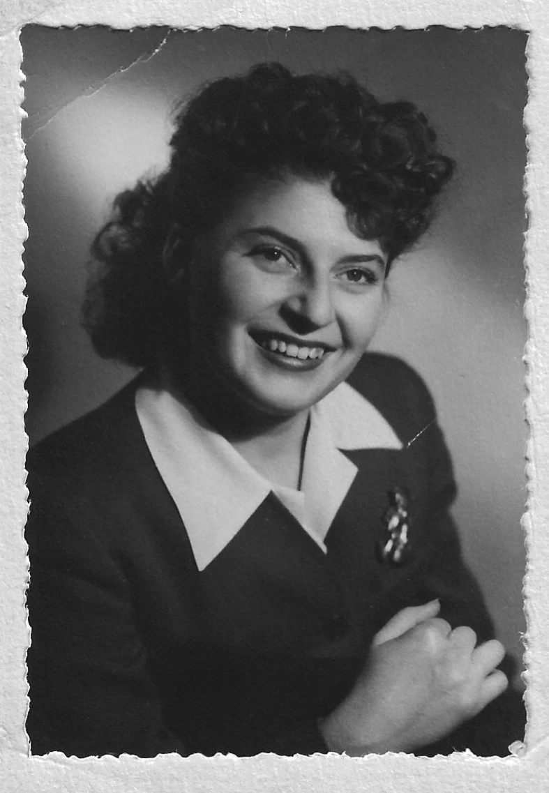 A woman smiles in a black and white portrait.