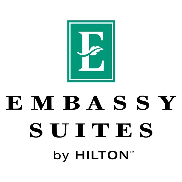 Embassy Suites by Hilton green and black lettering Logo