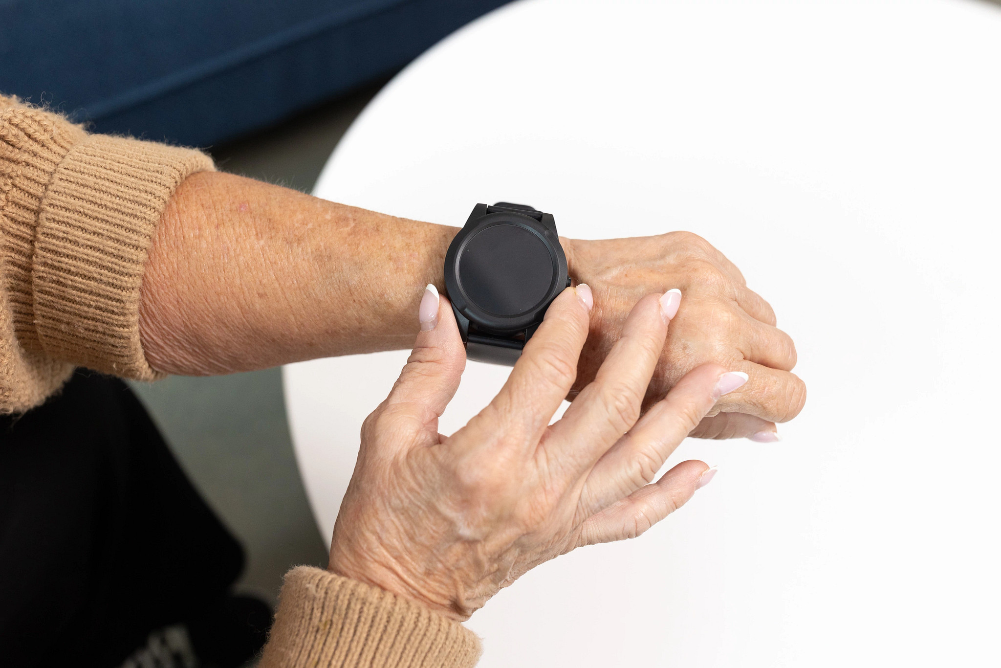 A woman wearing the LifeStation Sidekick Smart medical alert watch.