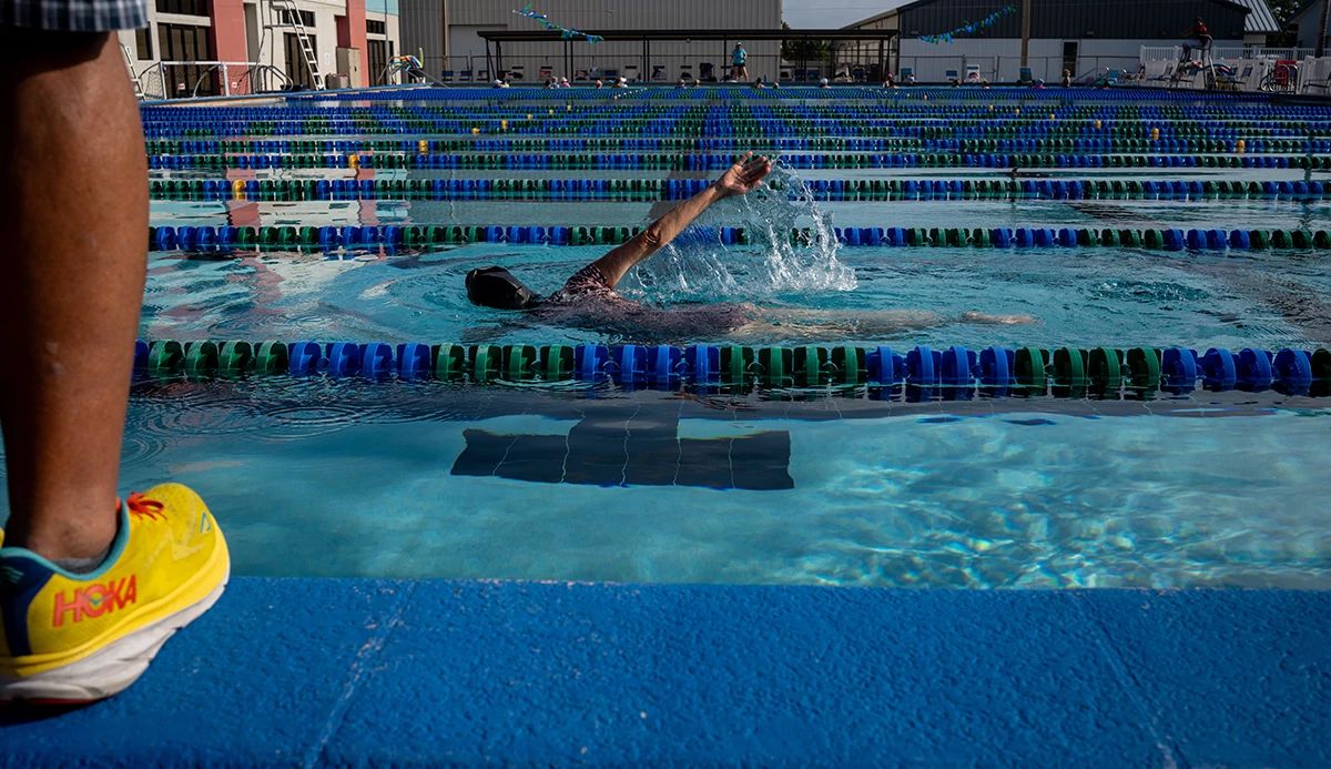 Swimming in the Water a swimmer is swimming while a coach looks on