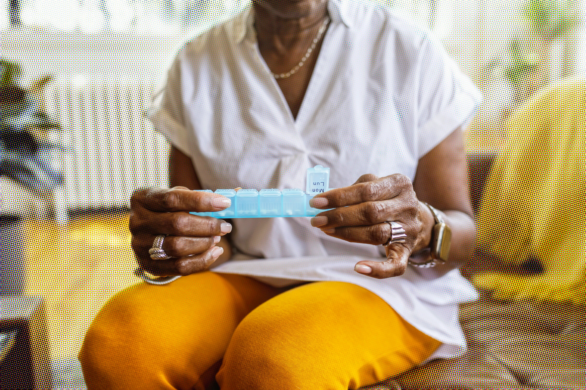 A person holding a light blue weekly pill box