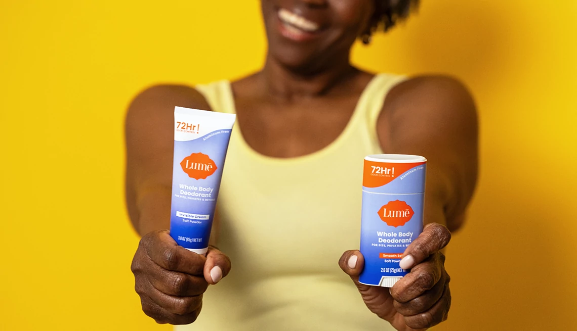 A woman holding a pair of Lume whole body deodorant