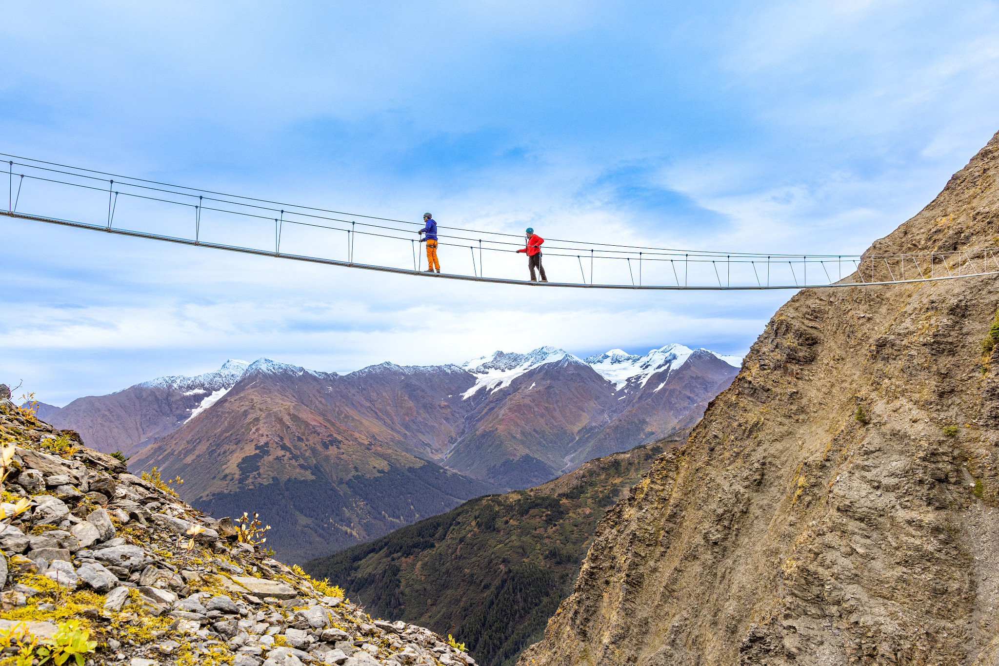 people crossing a suspension bridge