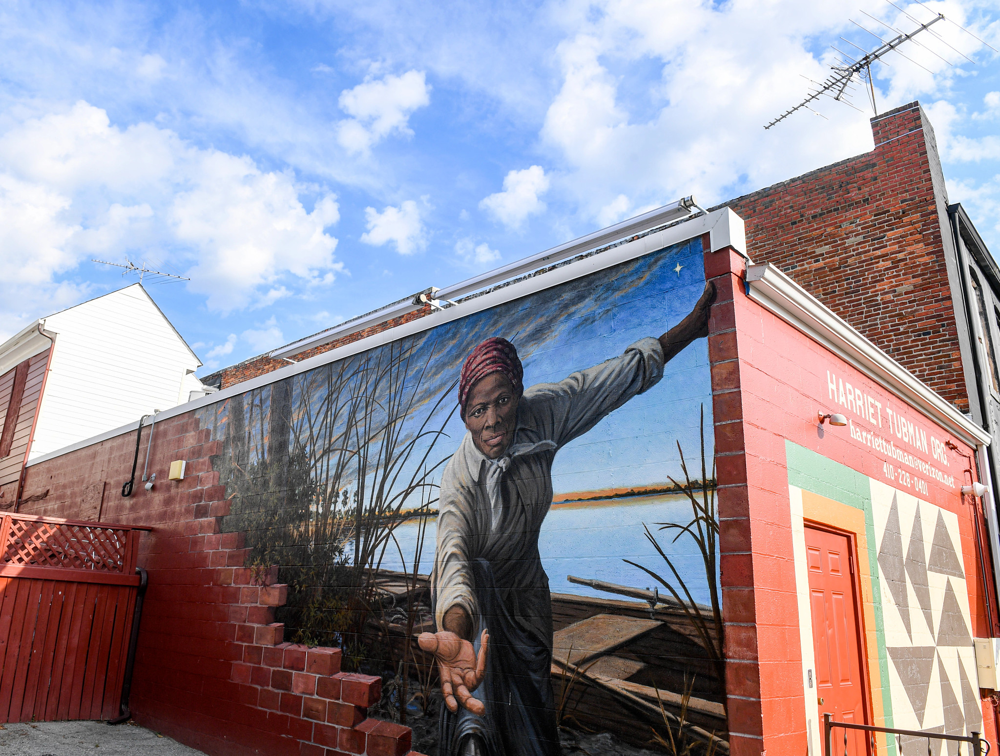 Mural of Harriet Tubman reaching out her hand on side of building