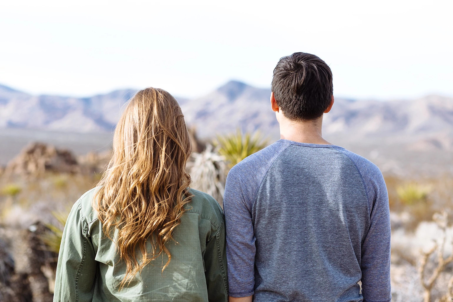 Male and female friends overlooking mountain scenery.