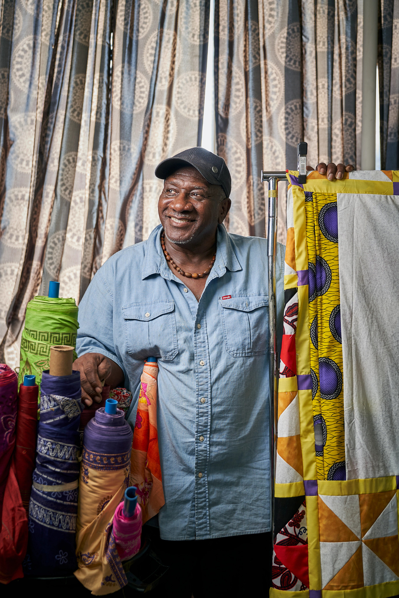 a photo shows Gary Tyler with spools of his quilts
