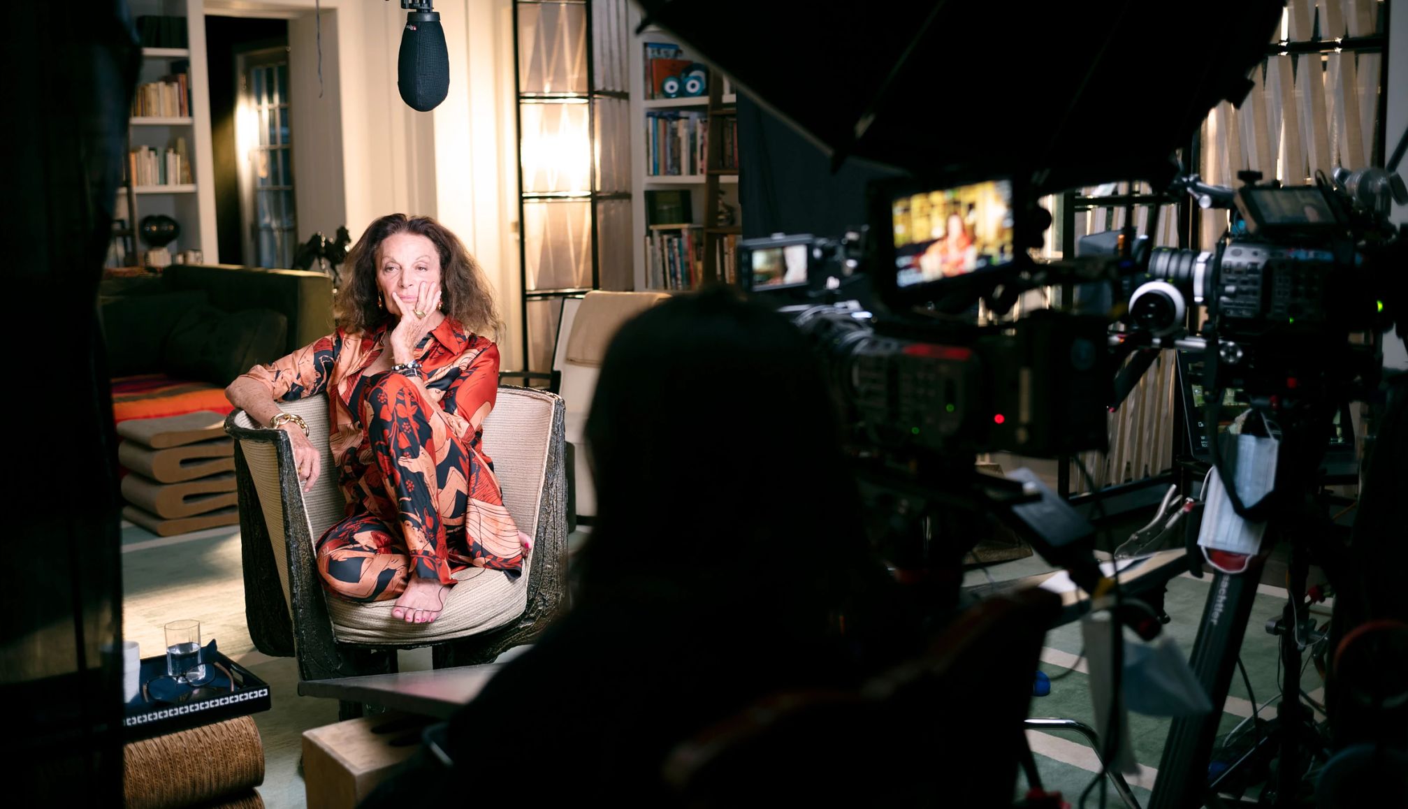 Diane von Furstenberg sitting on a chair with cameras filming her