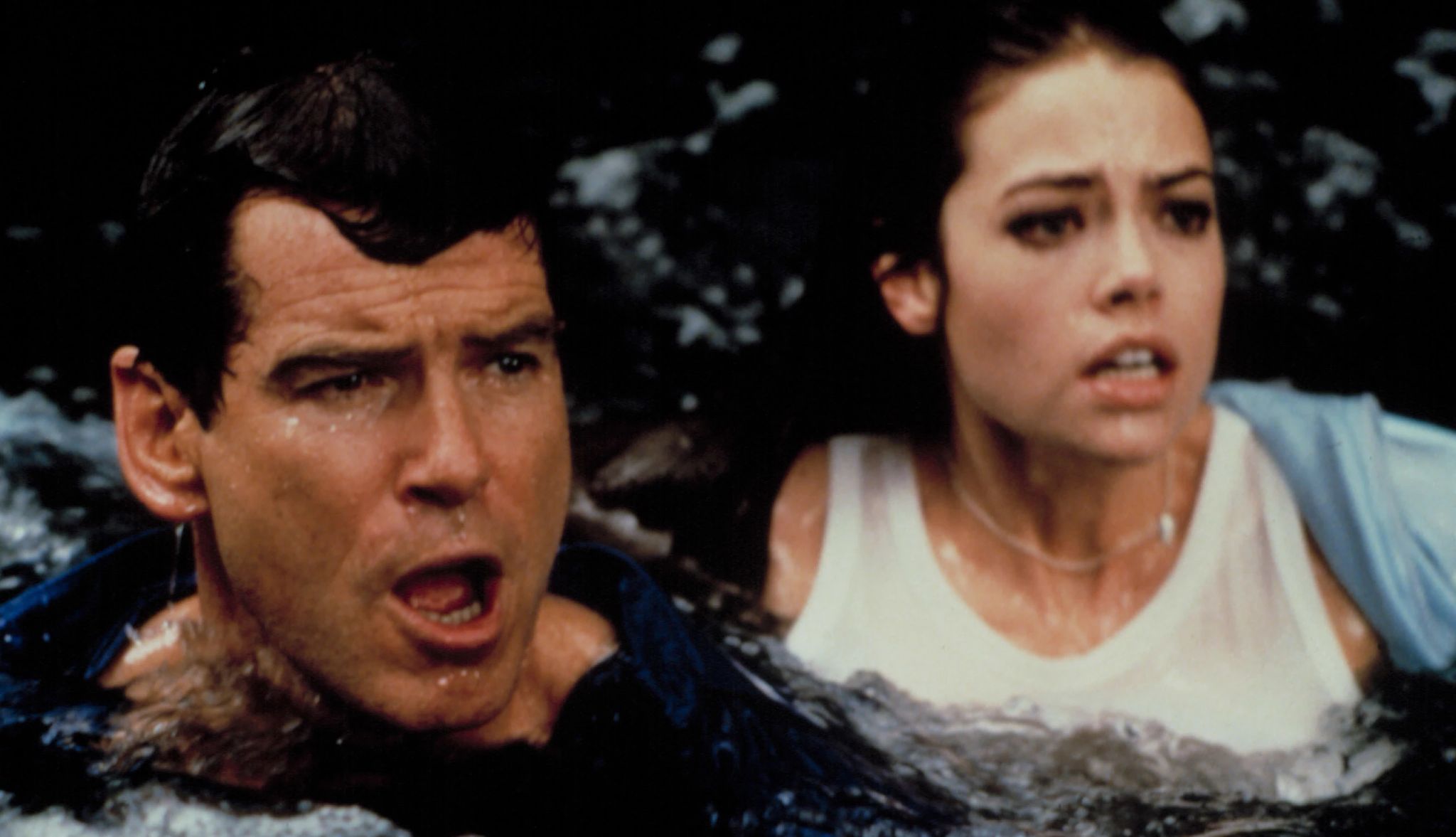 A scene from Bond movie “The World Is Not Enough” Close-up shot of Denise and Pierce Brosnan partially submerged in dark, murky water