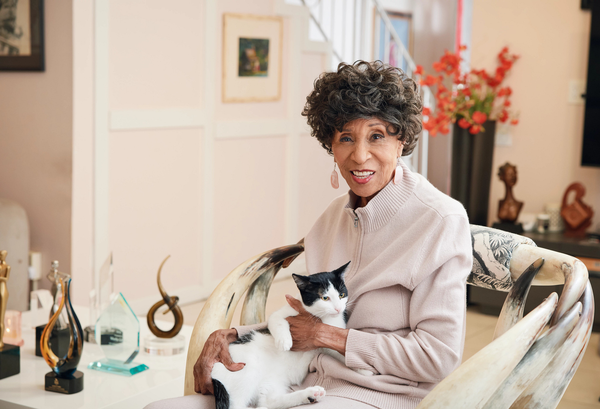 marla gibbs posing for a portrait with a black and white cat