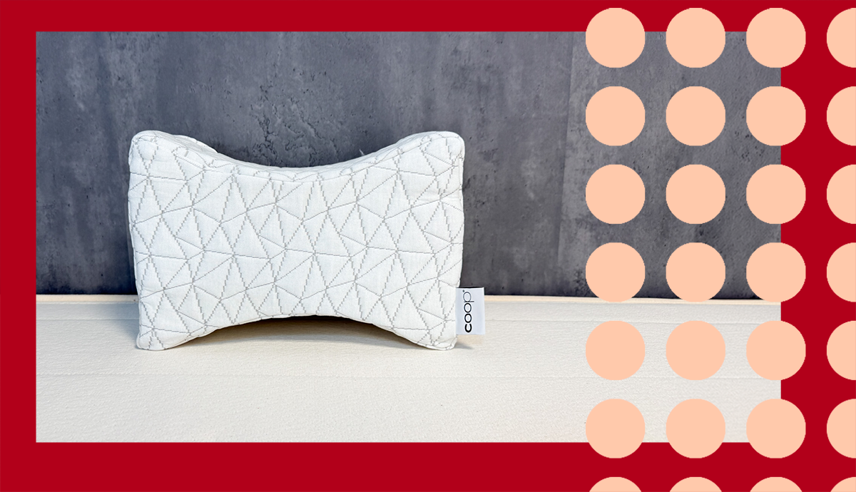 The Coop knee pillow on display in front of a gray wall