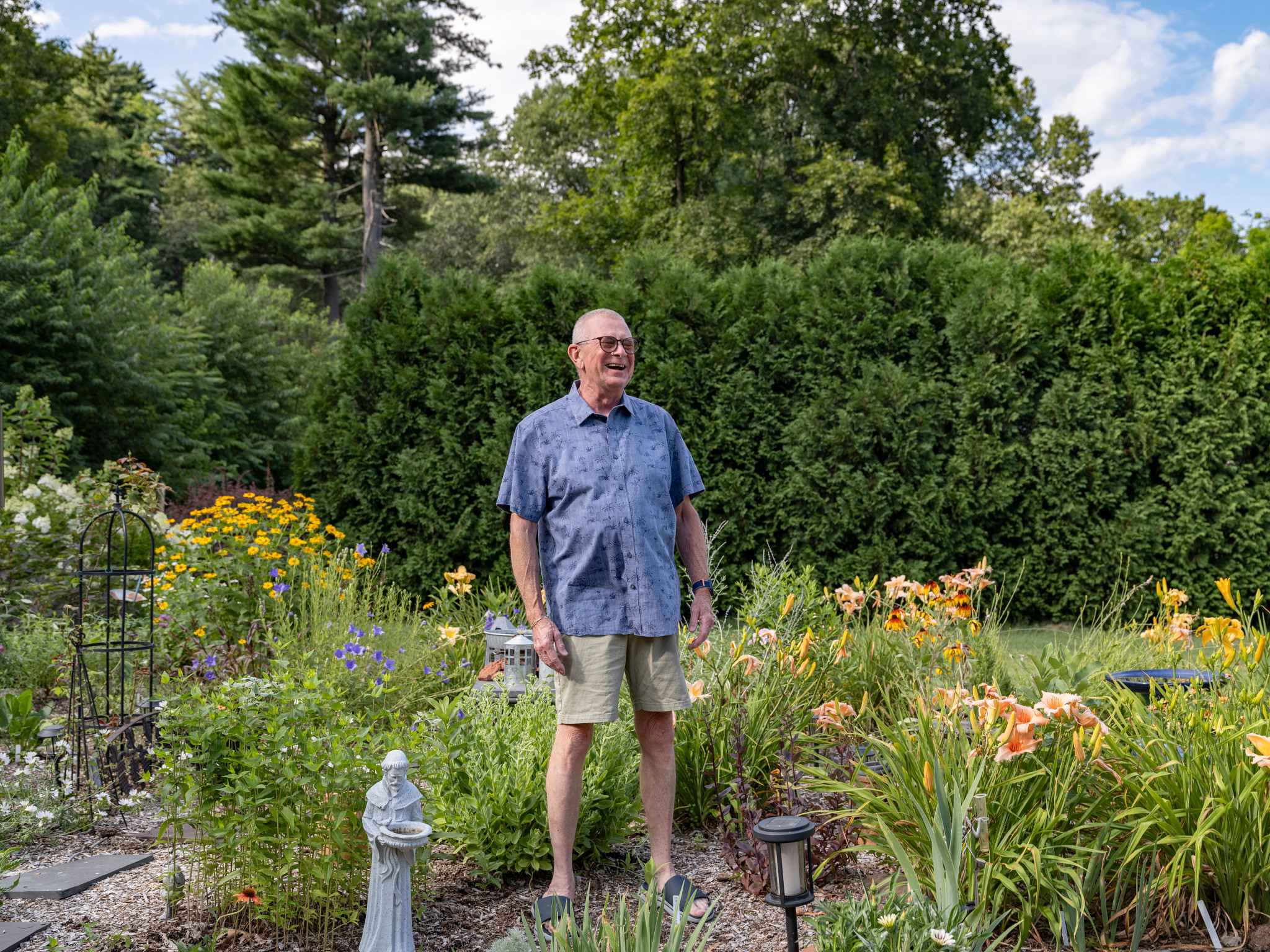 a man laughs in the middle of his garden
