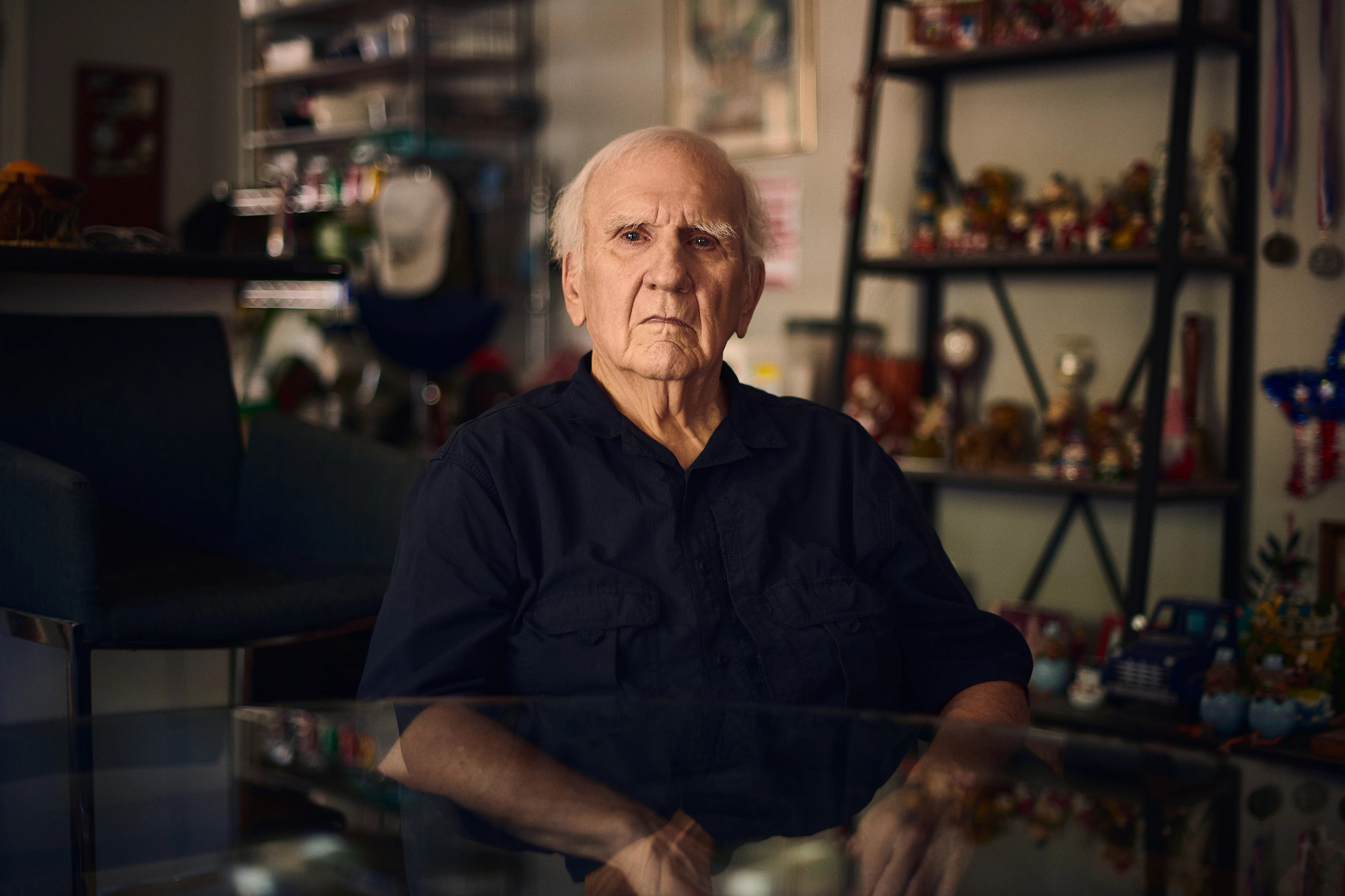an older man looks at the camera with a serious expression