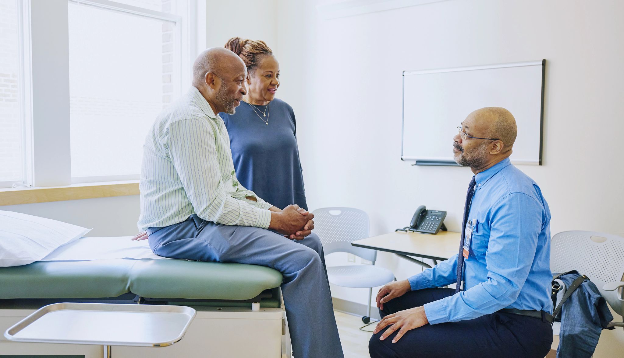 Clearly defined roles, open communication and flexibility can make caregiving more manageable A senior couple in discussion with a doctor in a medical exam room