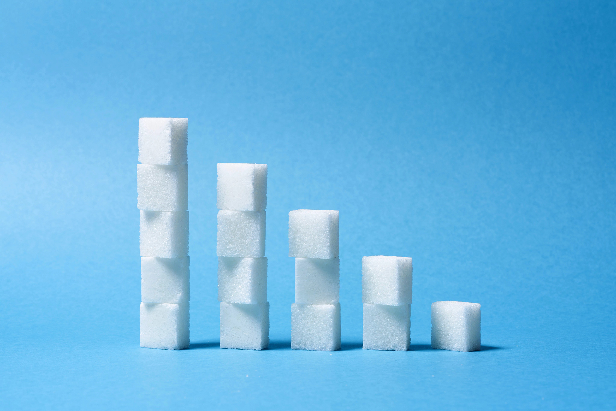 Sugar Cubes Stacks Bar Chart Ascending on Blue Background Front View.